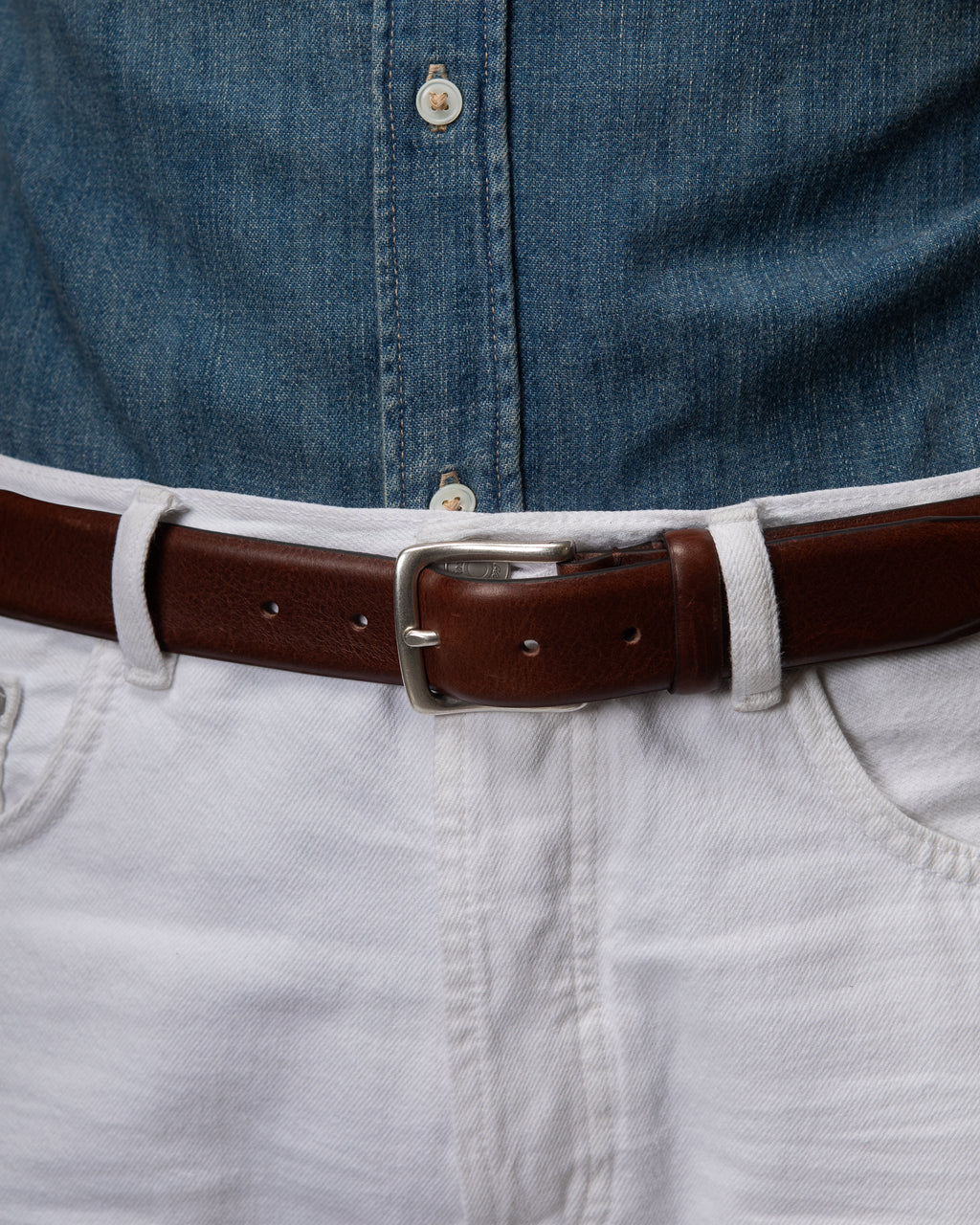C60 - Cintura in pelle testa di moro indossata con jeans bianchi e camicia in denim