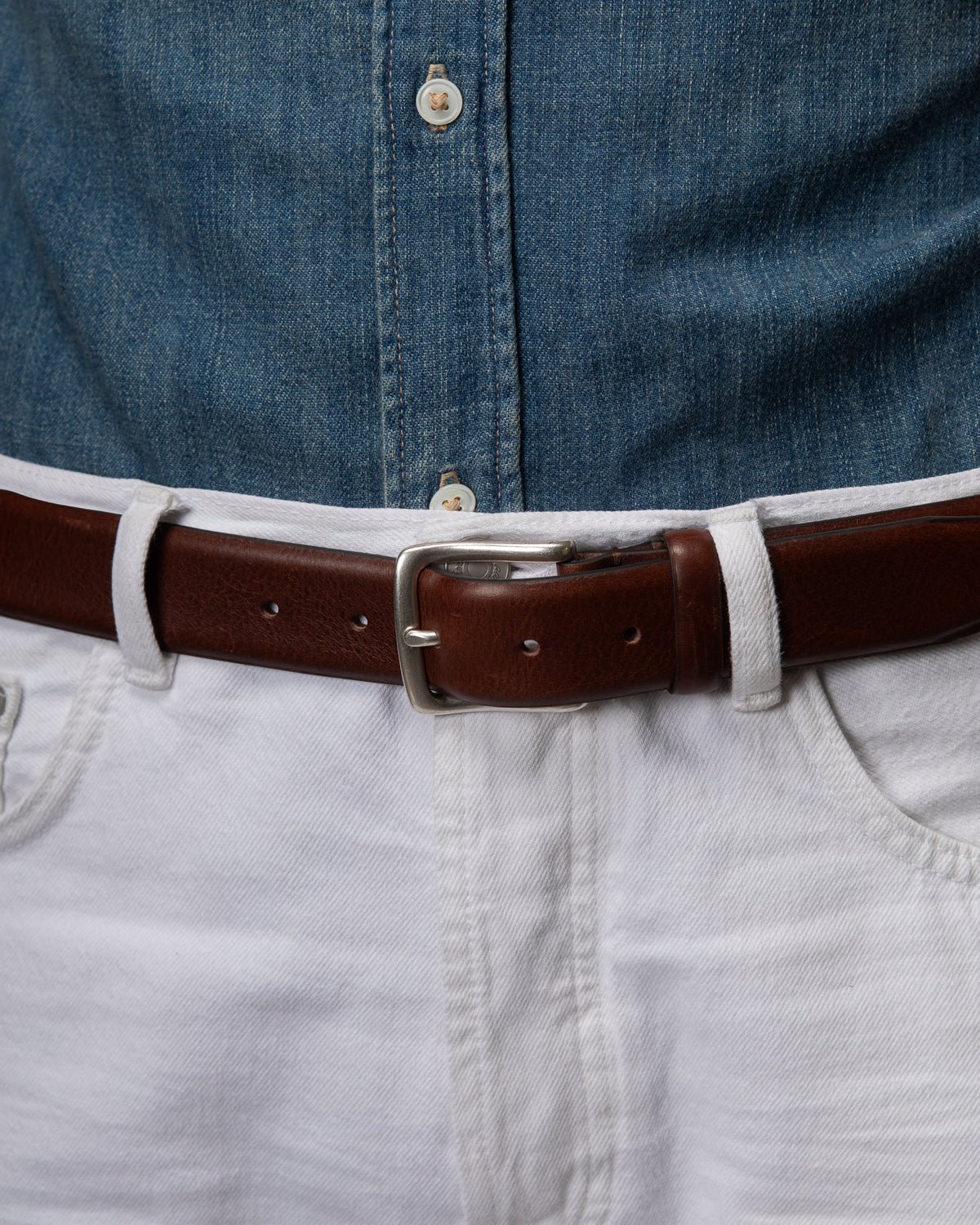 C60 - Cintura in pelle testa di moro indossata con jeans bianchi e camicia in denim